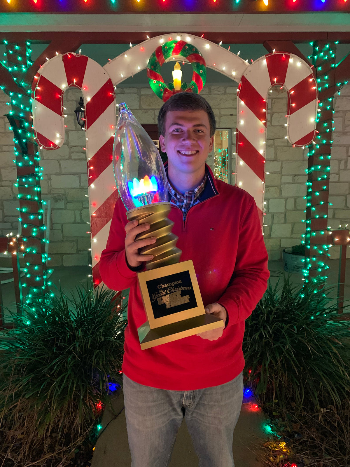 Jordan Maywald holding his Great Christmas Light Fight champion trophy